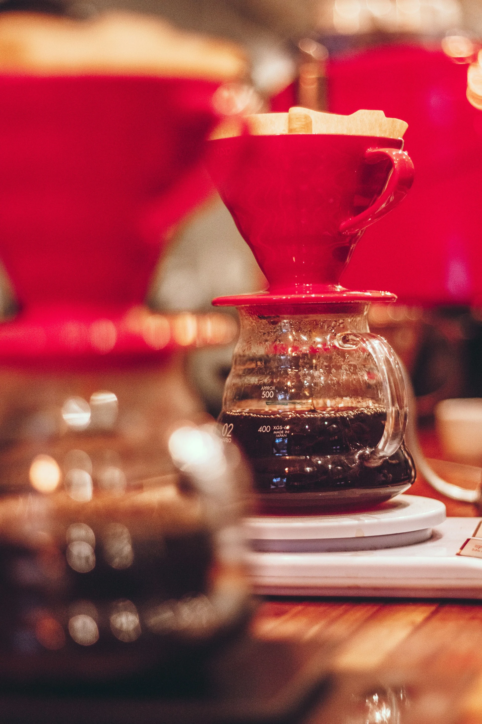 A pour-over coffee maker with a paper filter on a wooden table.