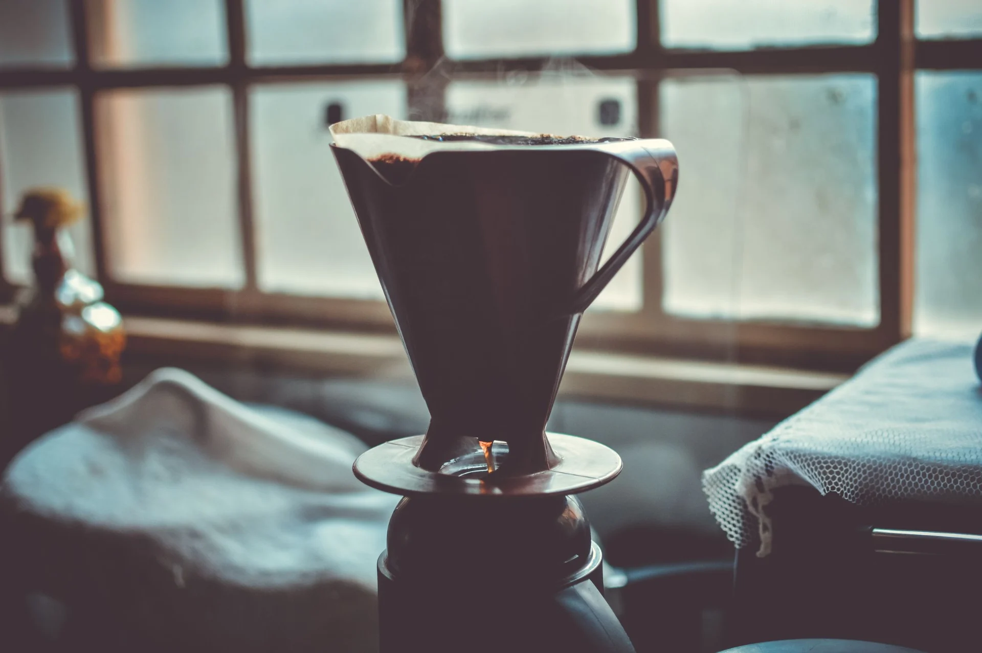 A pour-over coffee maker sits on top of a kettle.